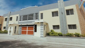 A modern two-story building with a garage, large windows, and a sign indicating a business. - Ljenj Apartelle (Mabalacat City)