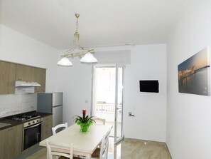 Une cuisine moderne avec une table à manger, des chaises et une plante.
