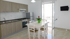 Una cocina moderna con armarios de madera, una estufa y una mesa de comedor con sillas.