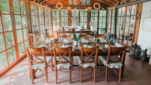 A wooden dining area with a large table set for a meal, surrounded by chairs. - The Lake House (Orhangazi)