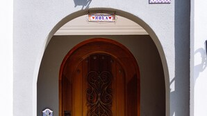 A hotel entrance with a wooden door, an arched doorway, a mailbox, and a sign above the door. - Flower Young B&B (Hualien City)