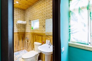 A bathroom with a wooden shower enclosure, a toilet, and a sink. - Flower Young B&B (Hualien City)