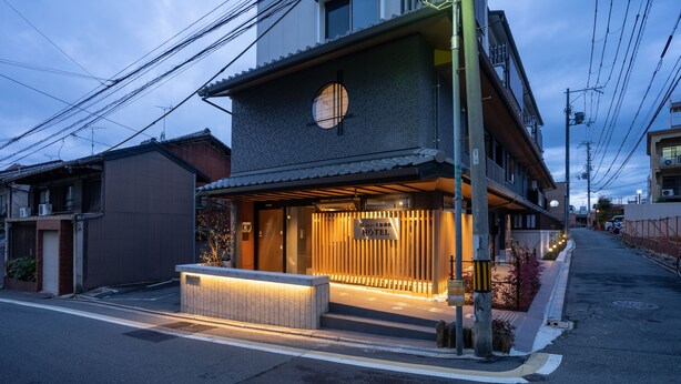 Un hotel japonés tradicional con fachada de madera y un gran ventanal circular.