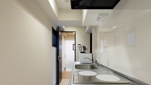 Una cocina moderna con un lavamanos de acero inoxidable, horno empotrado y microondas.