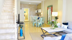 A modern living room with a sofa, a coffee table, and a dining area with chairs and a table. - Deluxe Penthouse Cathedral Views, 6 people, Parking optional (Sevilla)
