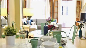 A dining area with a table set for two, a green plant, and a vase with flowers. - Deluxe Penthouse Cathedral Views, 6 people, Parking optional (Sevilla)