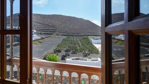A balcony with a view of a mountainous landscape and a parking area. - Beautiful Villa La Petit with Pool, Terrace, Garden and Wi-Fi (GUATIZA)