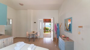 A hotel room with a bed, a desk, a chair, a dresser, and a view of the outdoors. - Sea & Sun (Rhodes)