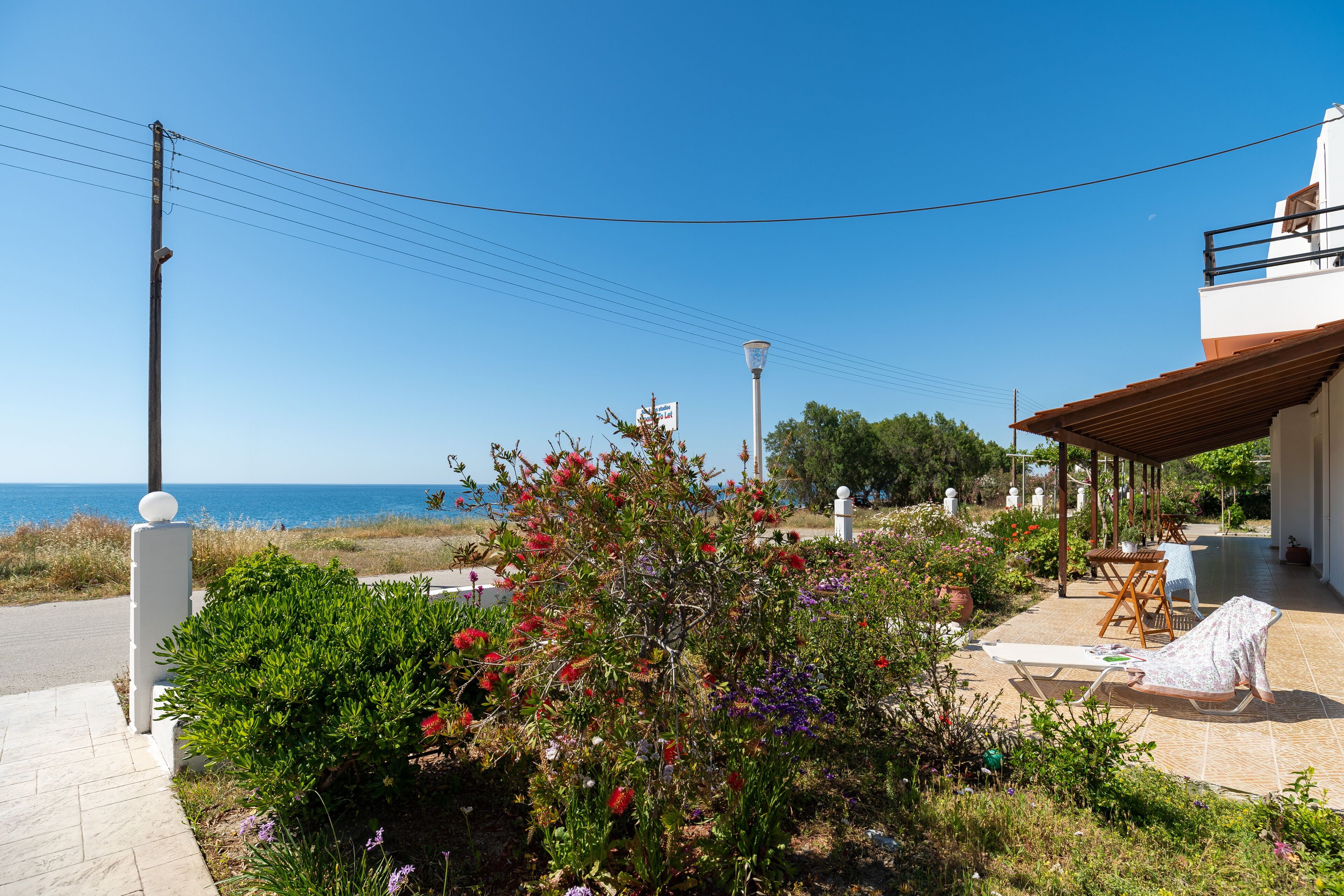 A coastal property with a patio, outdoor seating, and a view of the sea.