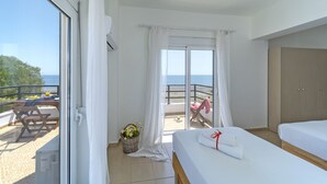 A hotel room with a balcony, a bed, a desk, and a view of the sea. - Sea & Sun (Rhodes)