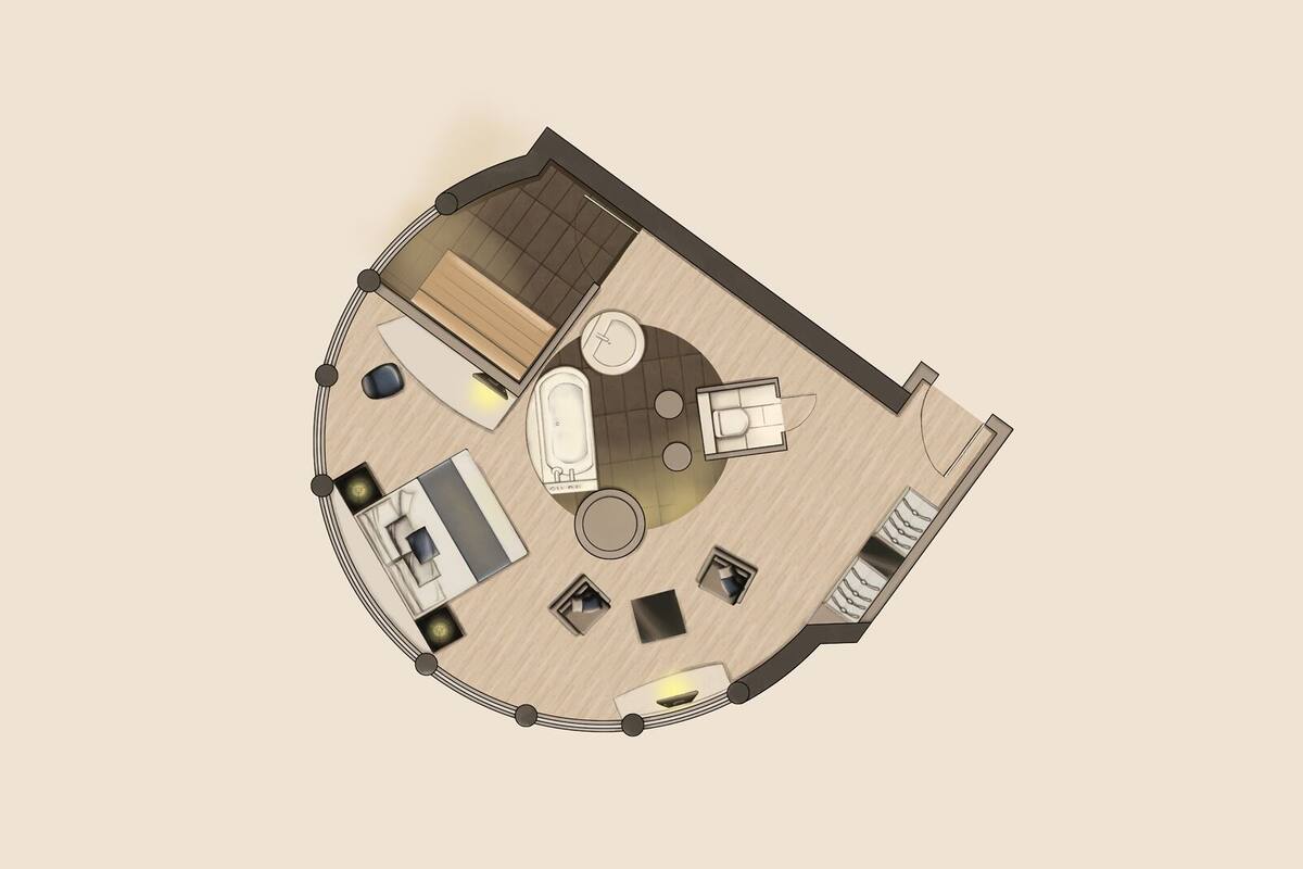 Vista de cima de um quarto de hotel com área de estar circular, banheira, cozinha compacta e banheiro separado.