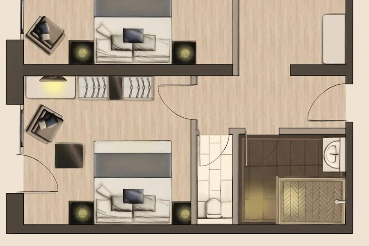 Disposição de quarto de hotel com uma cama, mesas de cabeceira, uma escrivaninha e um banheiro.