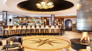 A bar area with a central fire feature, bar stools, and a star-patterned floor.