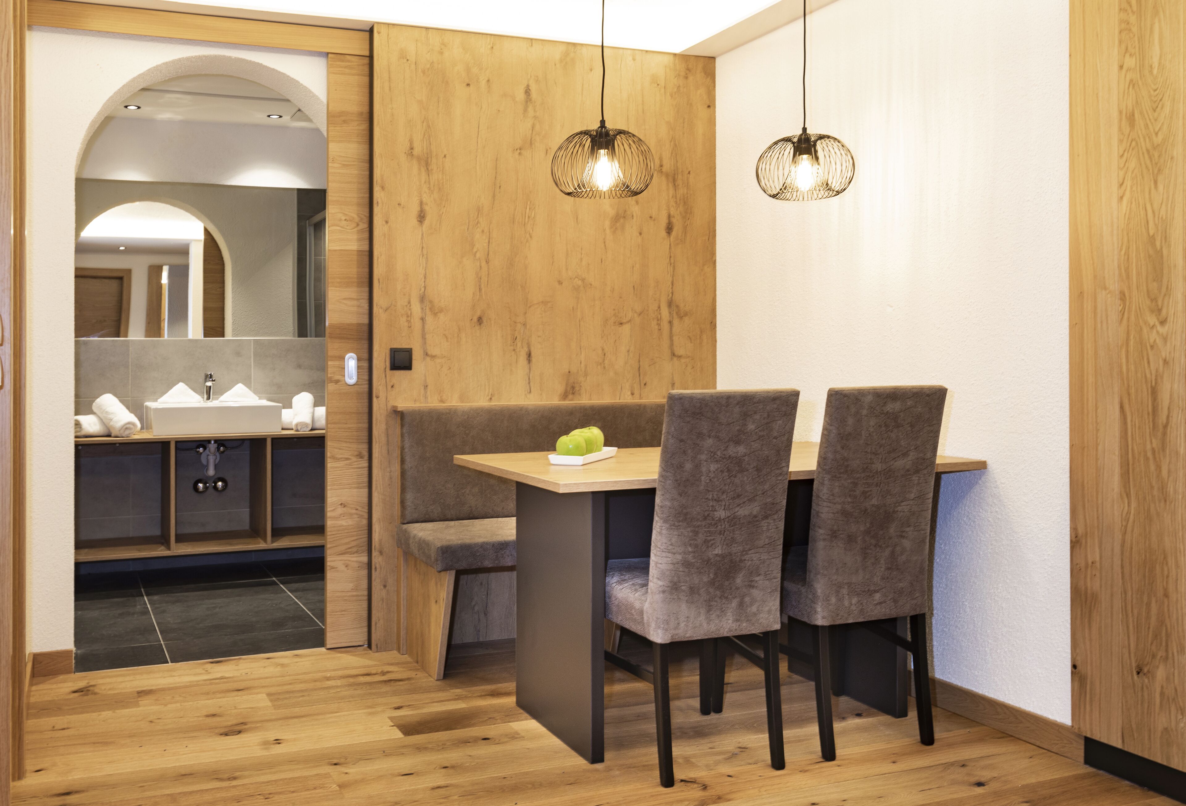 Een moderne badkamer met een houten wastafelmeubel, een wastafel en een spiegel.