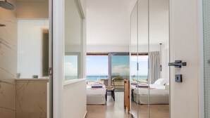 A modern hotel room with a large glass door leading to a balcony with a sea view. - Feyre Boutique Mansion-Echoes of the Sea by etouri (Rethymno)