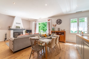 Una cocina moderna con comedor, chimenea y ventanas amplias.