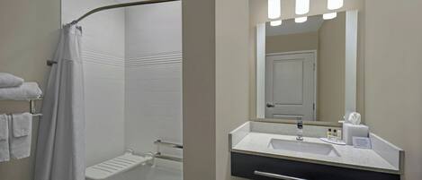 A modern bathroom with a shower, a sink, and a mirror.