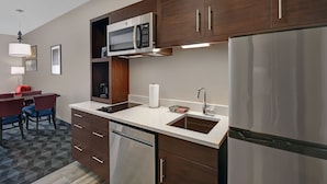A modern kitchen with stainless steel appliances, wooden cabinets, and a built-in microwave.