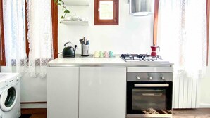Cocina compacta con lavadora, estufa y horno pequeño.