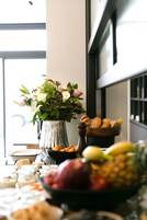 Una mesa con diversos alimentos y un jarrón de flores.