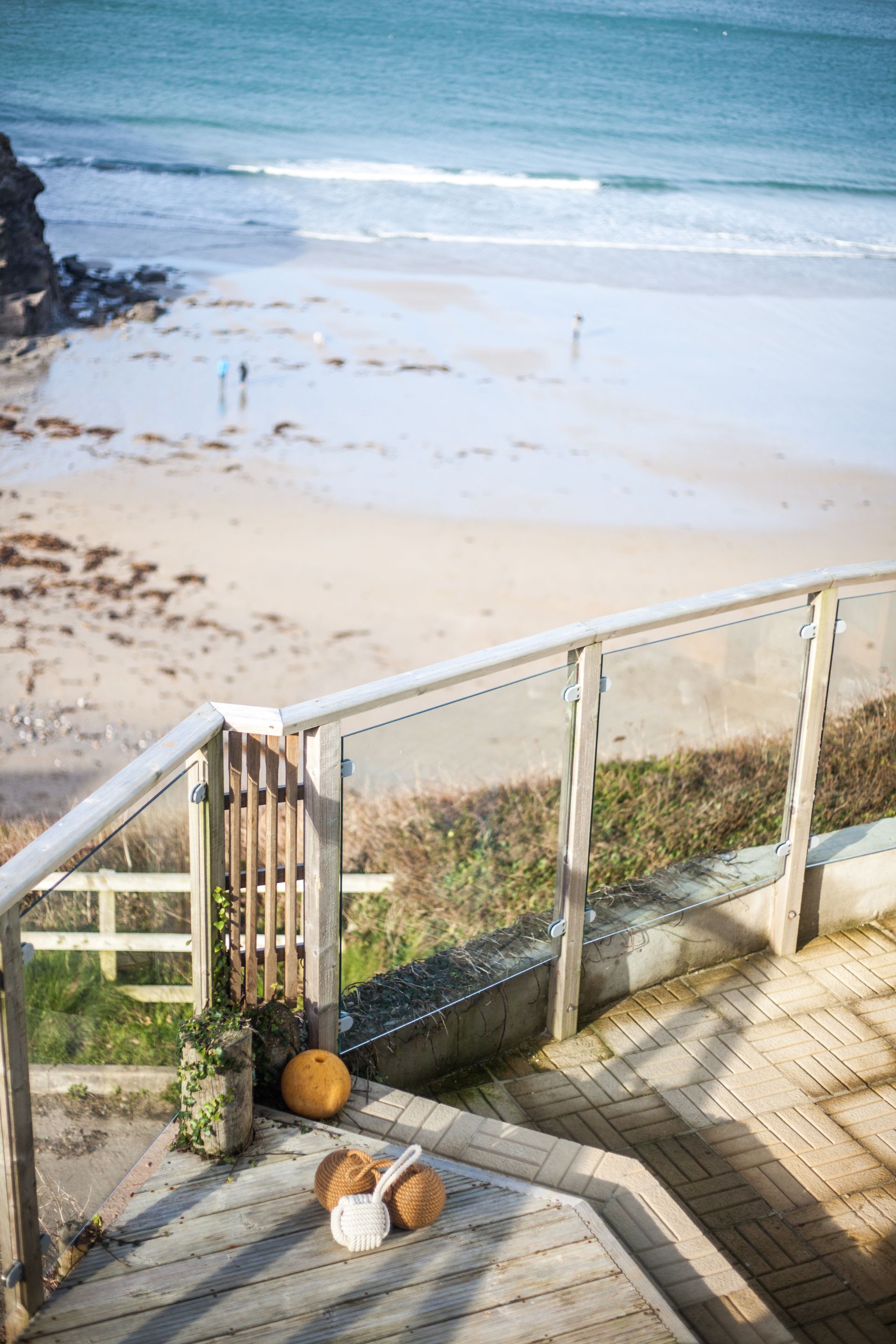 Una escalera de madera que lleva a una playa, con vista despejada al océano.