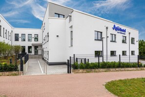 A modern white building with a sign reading "Aparthotel Am Pfaffenstein." - Aparthotel Am Pfaffenstein (Klein-Winternheim)