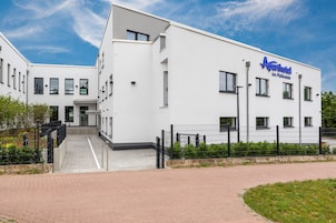 A modern white building with a sign reading "Aparthotel Am Pfaffenstein."