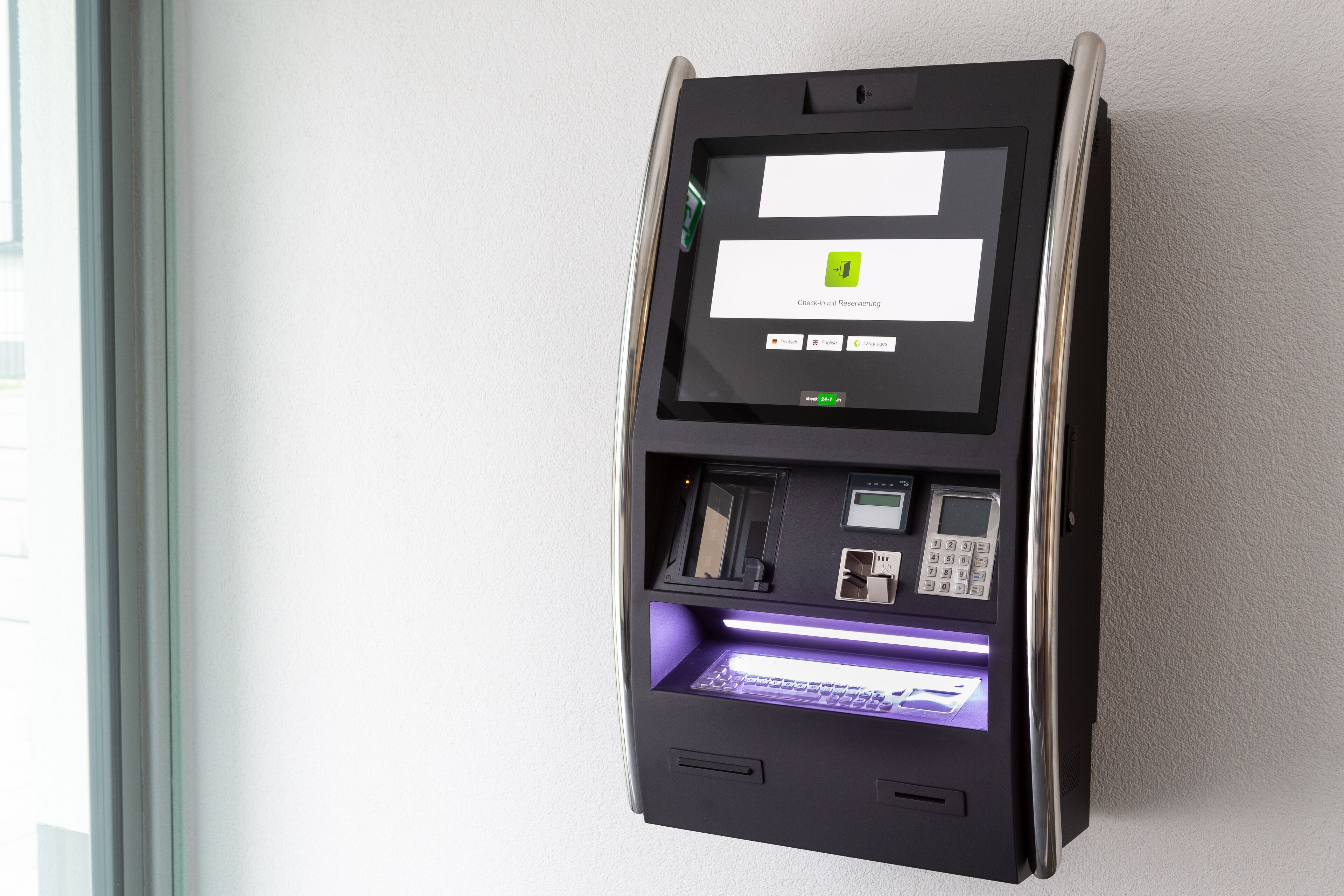 Un chiosco self-service con schermo, tastierino e lettore di carte, probabilmente per il check-in o per effettuare pagamenti.