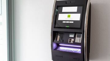 Un chiosco self-service con schermo, tastierino e lettore di carte, probabilmente per il check-in o per effettuare pagamenti.