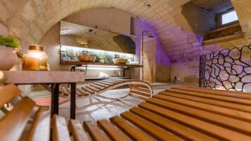 Un intérieur comprenant un banc en bois, une table et un coin cuisine avec une fenêtre.