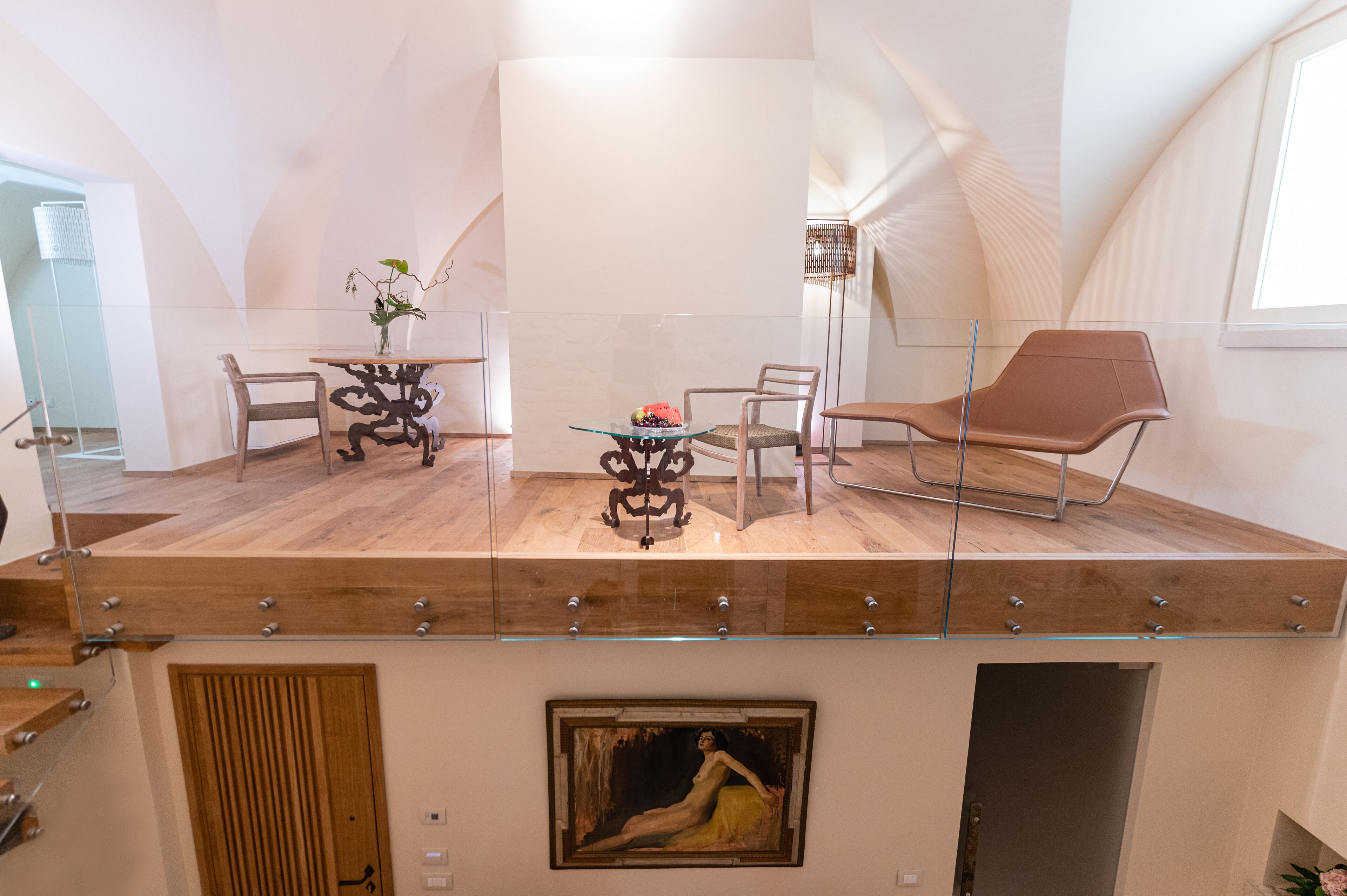 A modern interior with a dining area featuring a glass table, chairs, and a decorative vase.