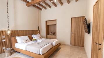 Une chambre moderne avec un plafond en bois, un lit doté d’une tête de lit, une table de chevet, un téléviseur fixé au mur et une armoire en bois.