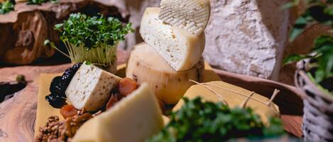 A variety of cheeses and nuts on a wooden board.