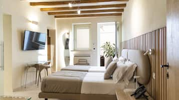 A modern bedroom with a large bed, bedside table, and a TV mounted on the wall.