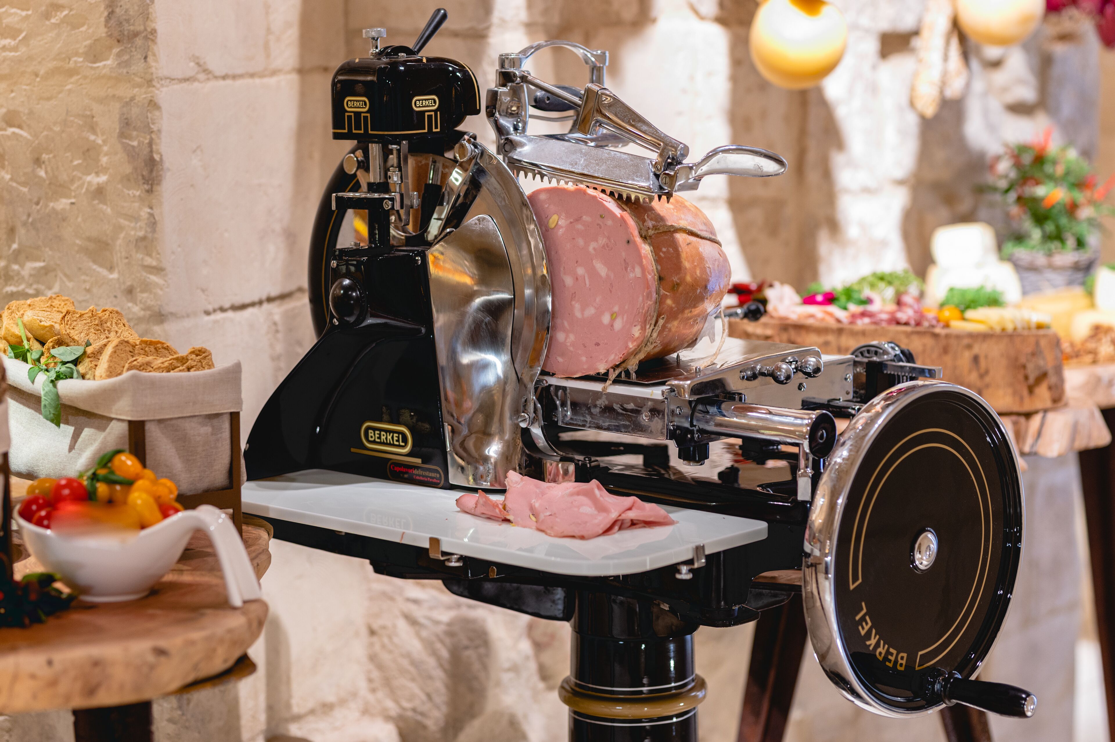 Un cortador de carne con una tabla de cortar blanca y un cuenco de fruta.