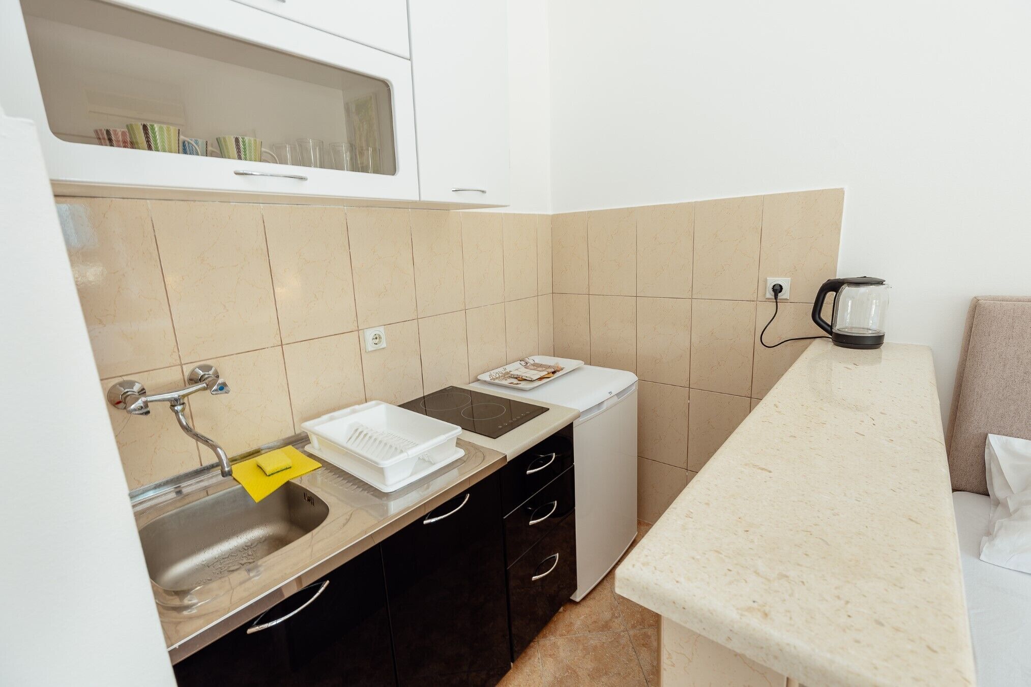 A compact kitchen with a sink, a dishwasher, and a countertop.