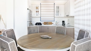 A modern kitchen with a central island, white cabinetry, and a striped backsplash. - Aries Villas | Villa Sagittarius – Private Pool & Aegean Sea Views (Skiathos)
