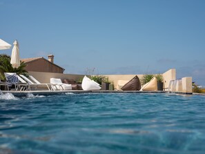 حمّام سباحة خارجي، مظلات على حمّام السباحة، مقاعد للتشمس