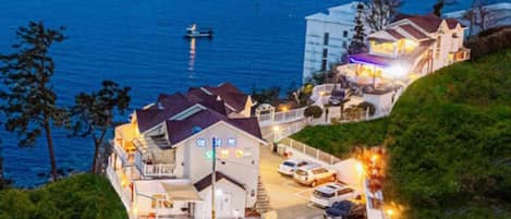 Un hotel costero con varias edificaciones, un estacionamiento y vistas al mar.
