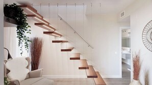 A modern staircase with wooden steps and a glass railing, leading to a white interior space. - AMAZING DUPLEX NEXT TO THE BEACH IN MARBELLA (Marbella)
