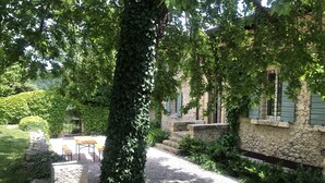 A stone building with a gravel pathway, a wooden bench, and a small table. - CA’ DEL BUSO   (VERONA)