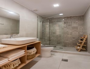 Un baño moderno con lavamanos grande, inodoro y zona de ducha.