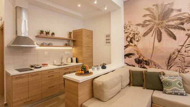 Una cocina moderna con armarios de madera, una estufa integrada y una encimera con frutero.