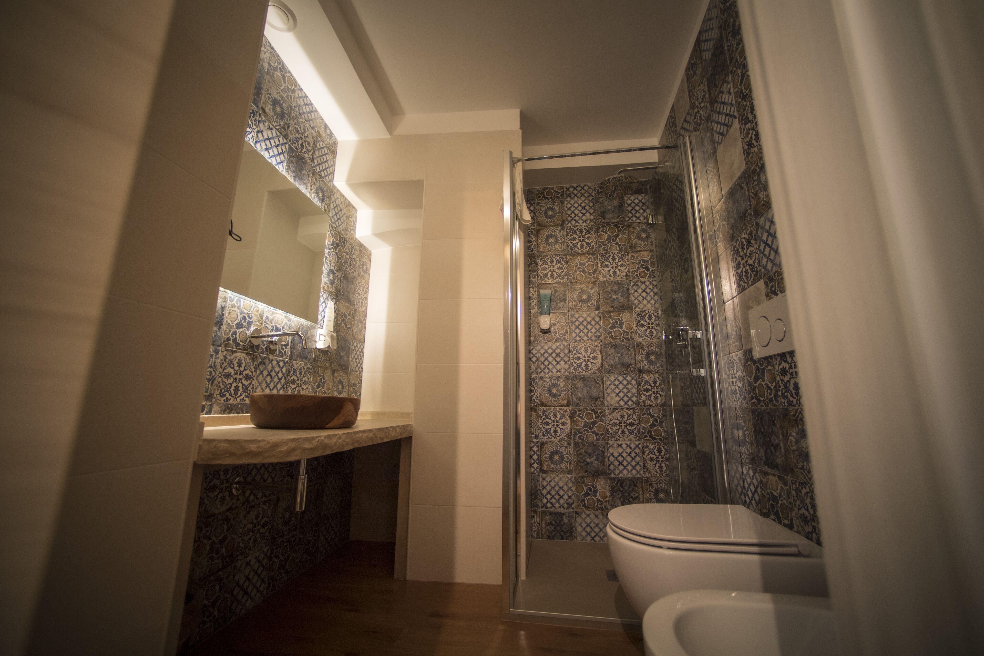 A bathroom with a shower, a sink with a bowl, and a toilet.