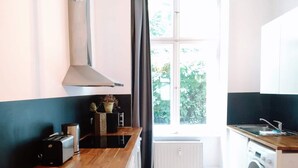 Een moderne keuken met een houten aanrecht, een inbouwoven en een raam met uitzicht op groen.