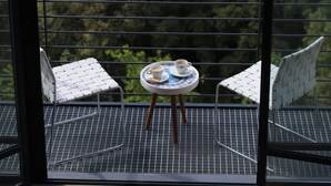 A balcony with two chairs and a small table with a cup and saucer. - The Silk Valley Resort (Aarbaniye)