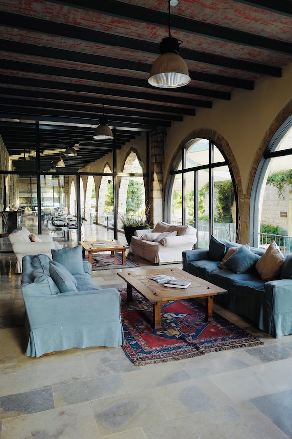 A spacious interior with a high ceiling, arched windows, and a mix of seating areas. - The Silk Valley Resort (Aarbaniye)