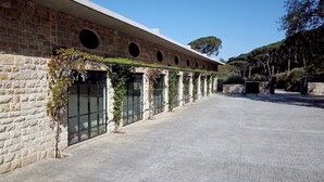 A building with a stone facade, large windows, and a paved courtyard. - The Silk Valley Resort (Aarbaniye)