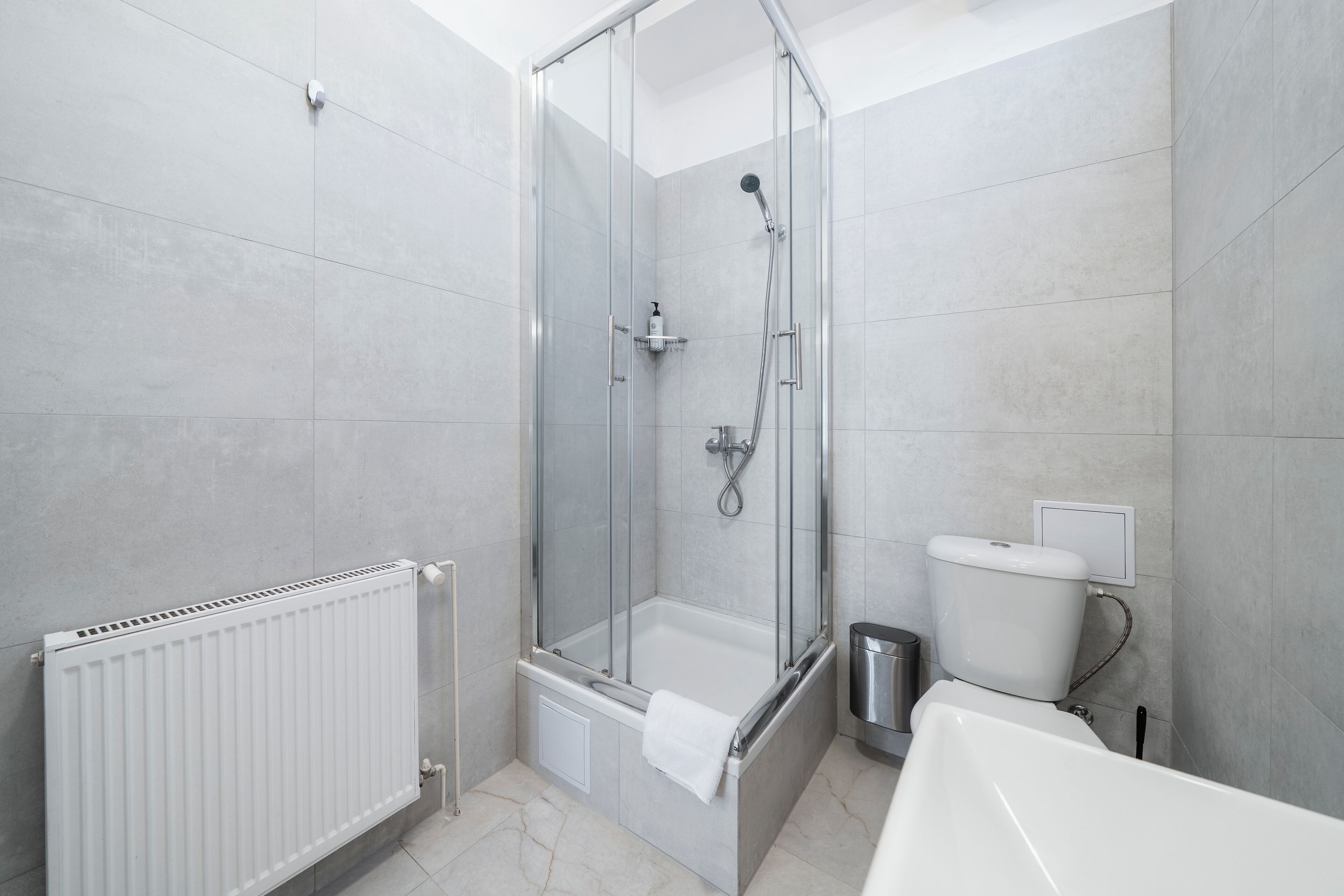Ein modernes Badezimmer mit einer Duschkabine, einer weißen Badewanne und einem WC.