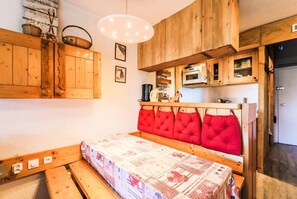Cozy retreat with a wooden bed frame, cabinet, and microwave.